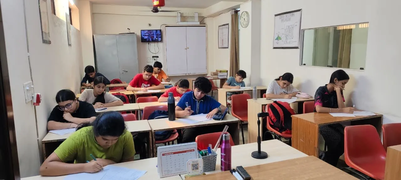 A second classroom, students writing at their desks.