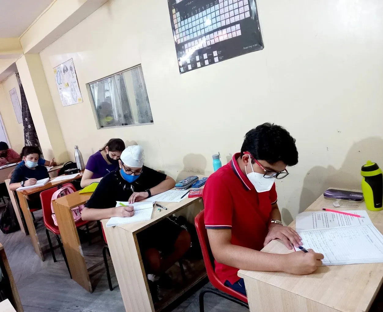 Students writing at individual desks.