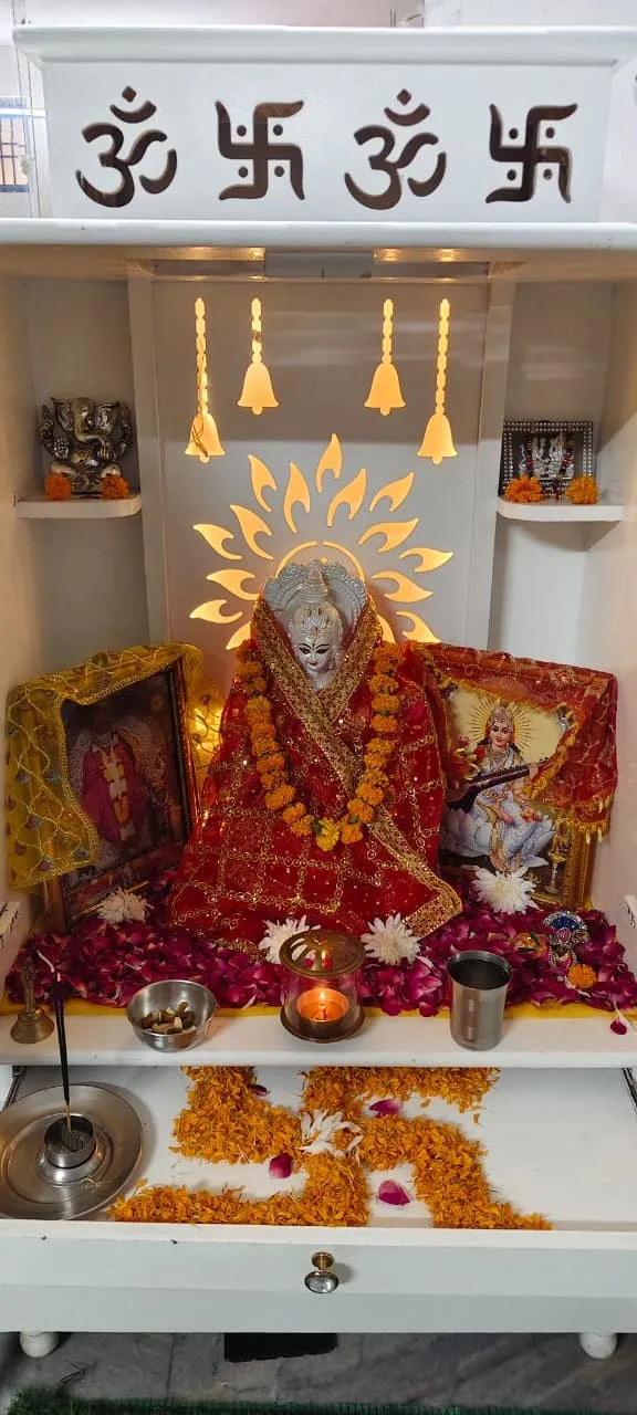 The prayer corner, decorated with marigold garlands and a lit oil lamp.